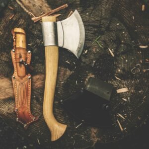 A rugged camping axe and knife on a tree stump, perfect for bushcraft and outdoor adventures.